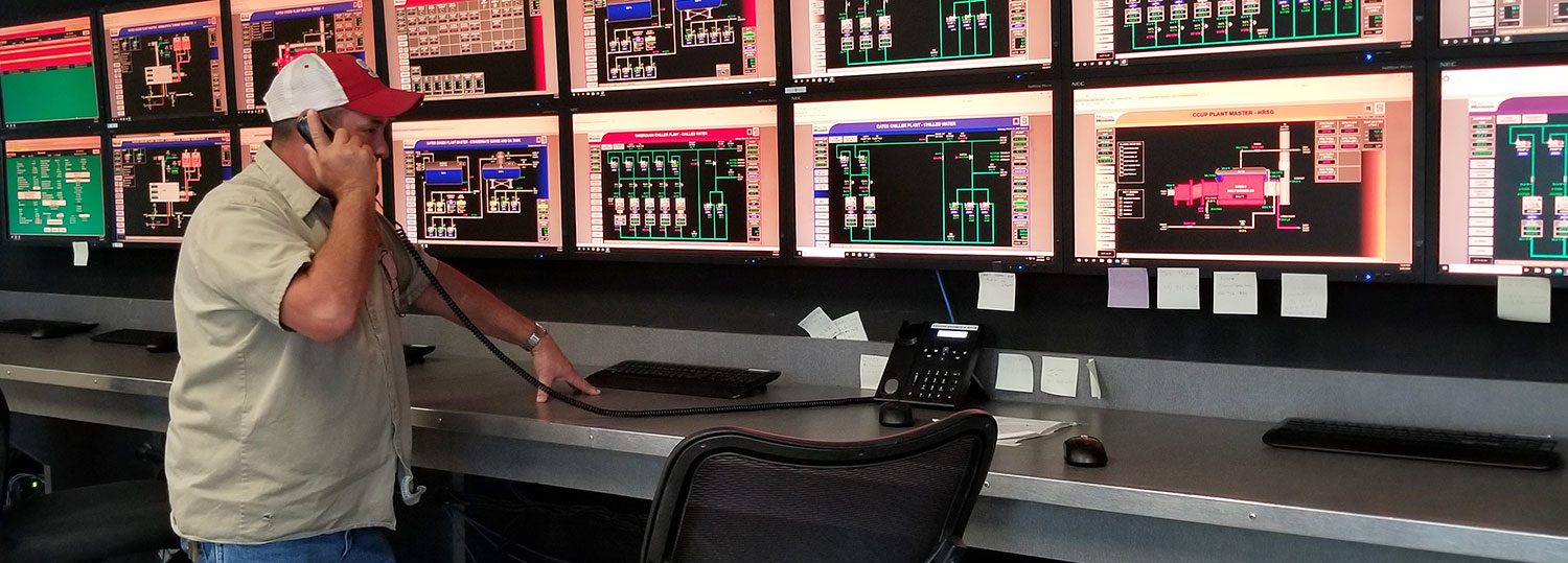 A central utility plant operator on the phone in a control room