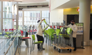 Workers remove green chairs from Talley Student Union to limit seating capacity during the COVID-19 pandemic.